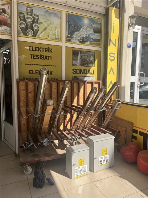 Dükkân girişinde sergilenen metal dalgıç pompalar ve elektrik panoları